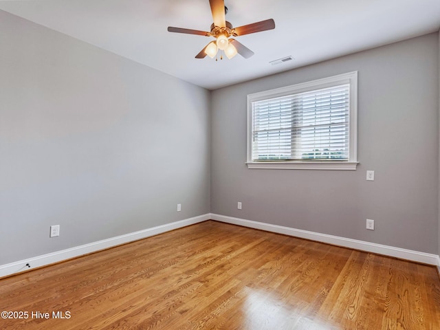 empty room featuring visible vents, baseboards, light wood-style flooring, and a ceiling fan