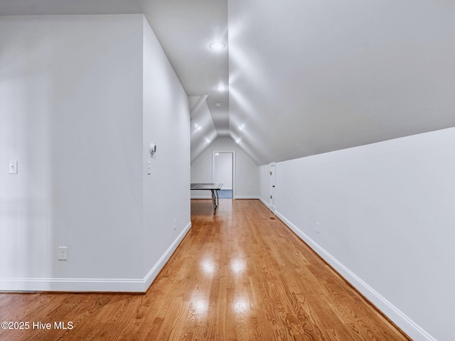 bonus room featuring lofted ceiling, baseboards, and light wood finished floors