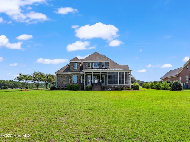 view of front of house featuring crawl space, brick siding, a front lawn, and a sunroom