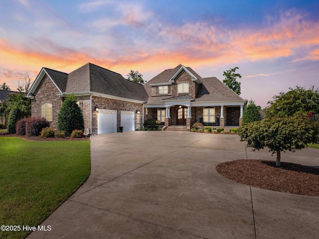 view of front of house featuring a lawn, roof with shingles, concrete driveway, and an attached garage