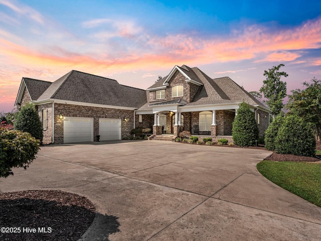 view of front of house featuring brick siding, an attached garage, driveway, and roof with shingles