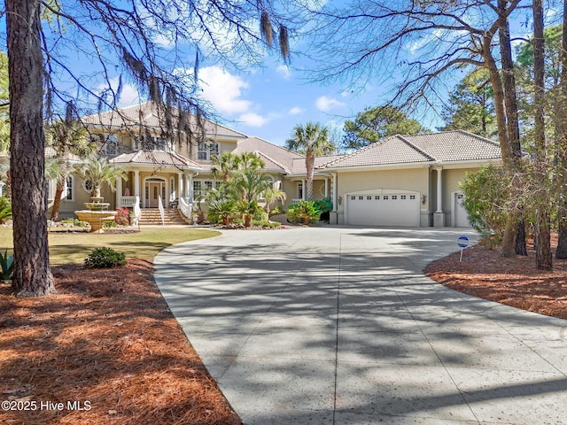 view of front of house featuring stucco siding, an attached garage, driveway, and a tile roof