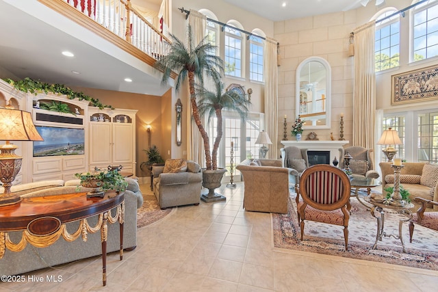 2760 Marsh Point Ln SE, Southport, NC 28461 - living room featuring a towering ceiling, a glass covered fireplace, recessed lighting, and light tile patterned floors