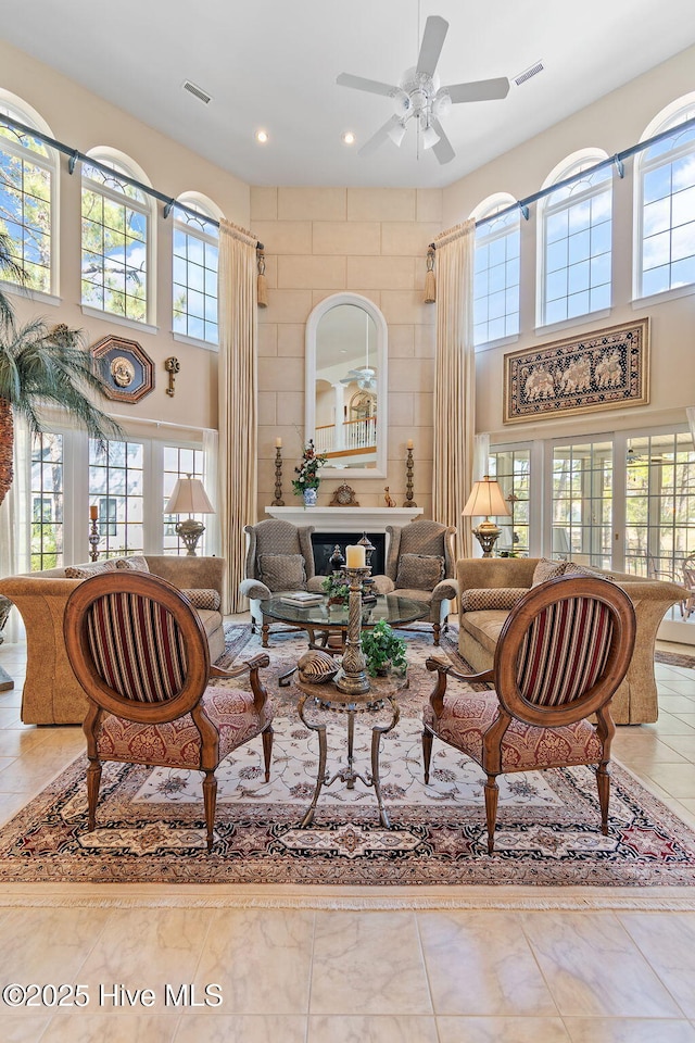living room featuring a towering ceiling, a ceiling fan, recessed lighting, tile patterned floors, and french doors