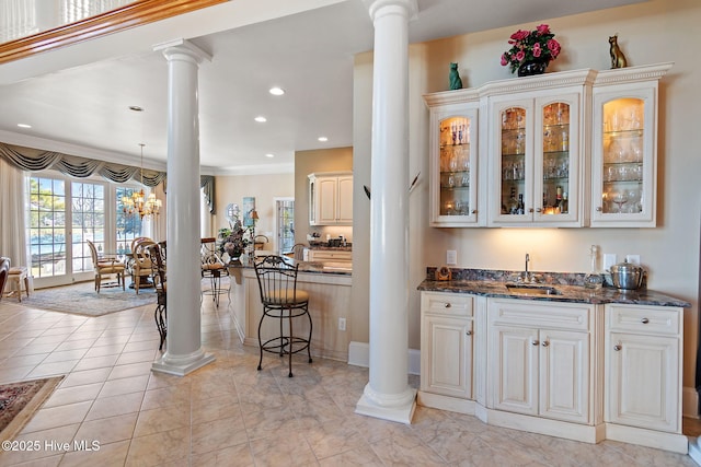 indoor wet bar featuring ornate columns and recessed lighting