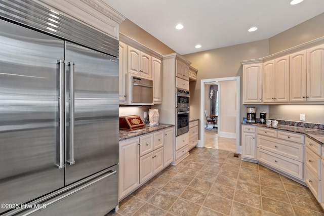 kitchen with stainless steel appliances, recessed lighting, dark stone countertops, and baseboards