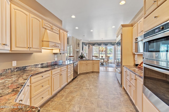 kitchen featuring appliances with stainless steel finishes, a peninsula, premium range hood, dark stone countertops, and recessed lighting