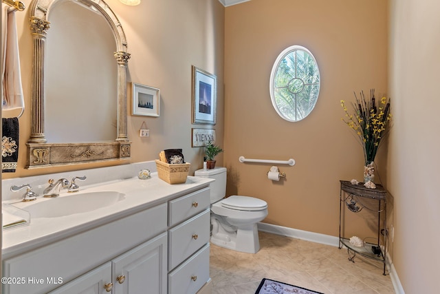 bathroom with toilet, vanity, and baseboards