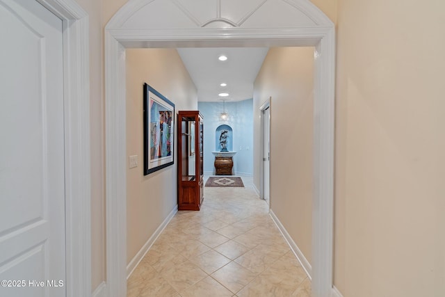 hall featuring baseboards, recessed lighting, and light tile patterned floors