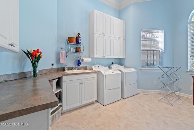 clothes washing area featuring cabinet space, independent washer and dryer, and crown molding