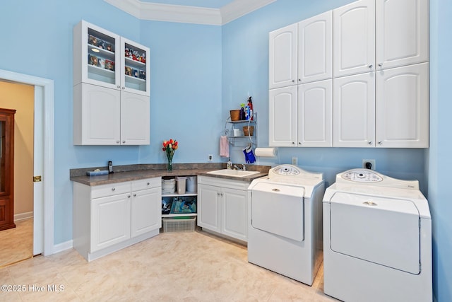 clothes washing area featuring cabinet space, independent washer and dryer, and ornamental molding