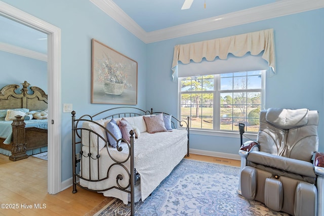 bedroom featuring wood finished floors, crown molding, baseboards, and ceiling fan