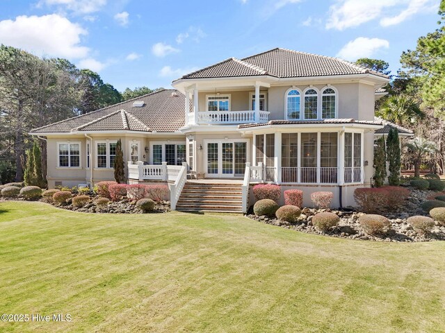 2760 Marsh Point Ln SE, Southport, NC 28461 - back of house featuring a balcony, stairs, a yard, and a tile roof