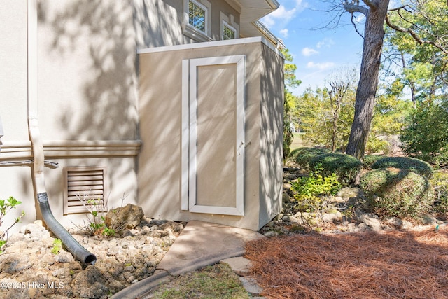 entry to storm shelter with a shed and an outdoor structure