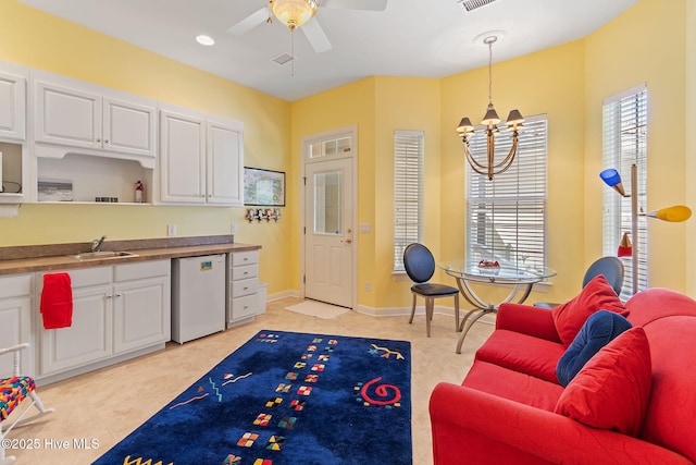 recreation room with a sink, a chandelier, ceiling fan, and light tile patterned floors