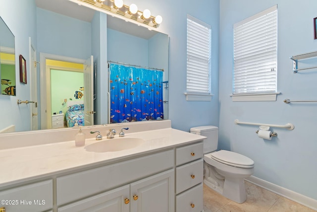 full bathroom featuring toilet, tile patterned flooring, vanity, baseboards, and plenty of natural light