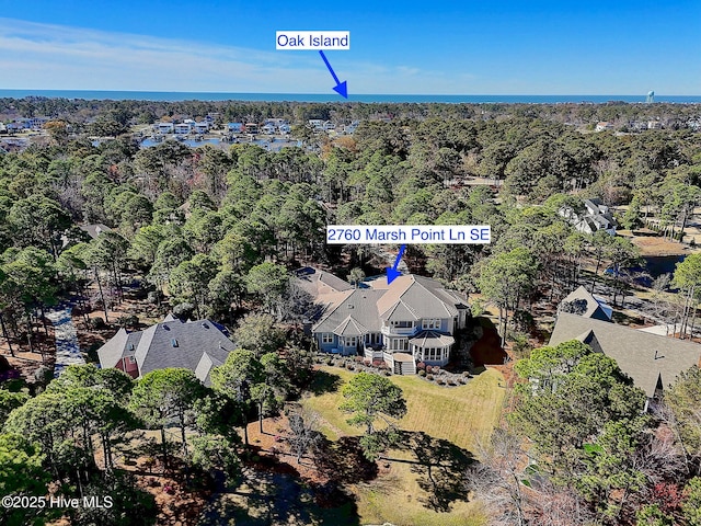 aerial view of property and surrounding area featuring a heavily wooded area