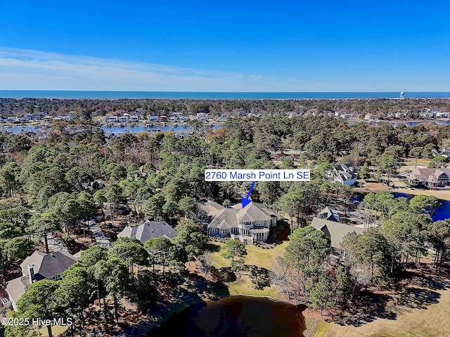 aerial view of property's location with a nearby body of water and nearby suburban area