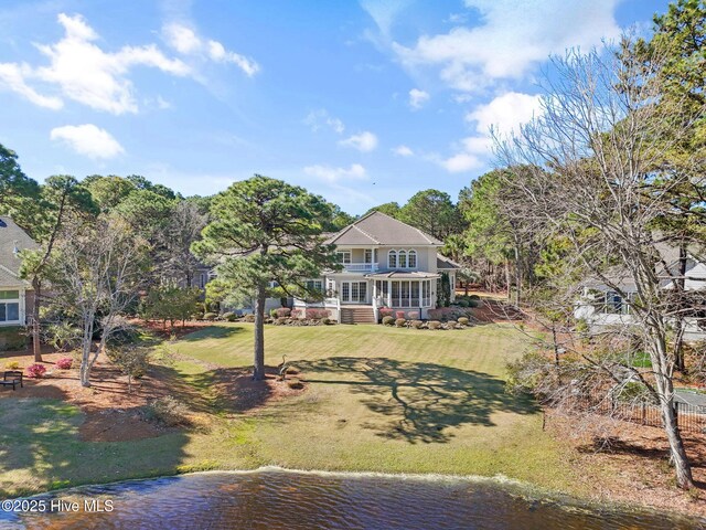 back of house featuring a yard and a water view