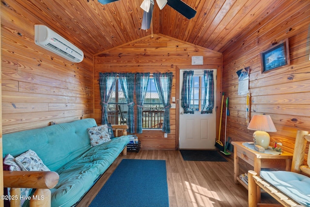 living area with wood finished floors, a ceiling fan, wood walls, and a wall mounted AC