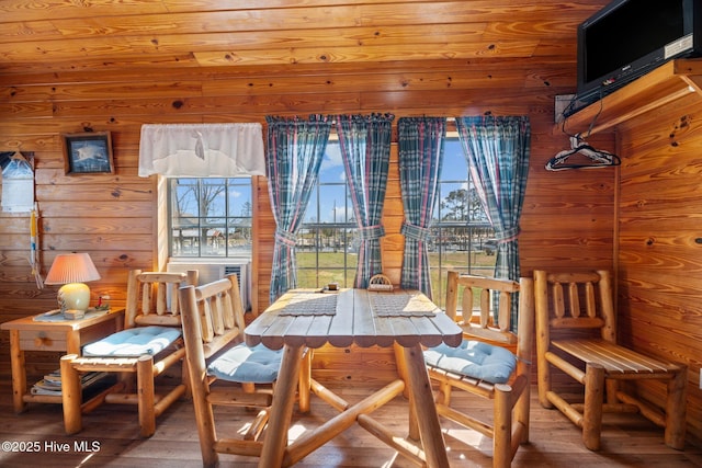 dining area with wooden walls and wood finished floors