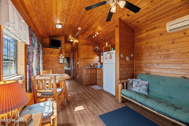 living area with vaulted ceiling, wood finished floors, wood ceiling, and a wall mounted air conditioner