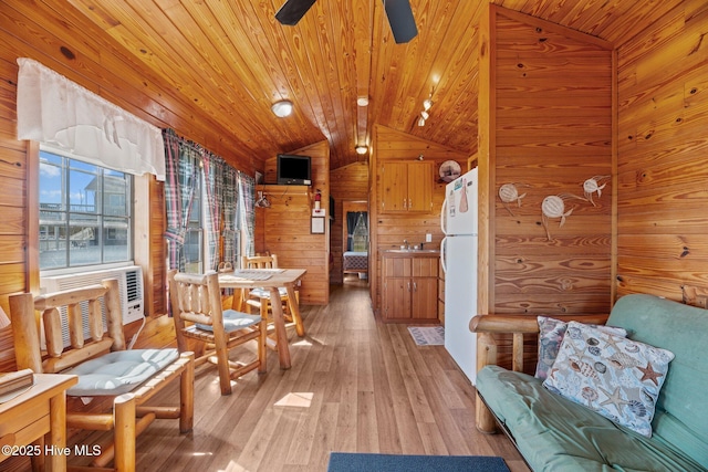 interior space featuring wooden walls, wooden ceiling, ceiling fan, and vaulted ceiling