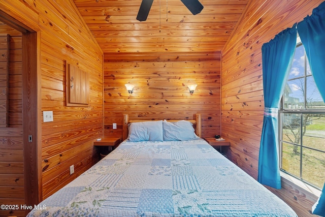 bedroom with wooden walls, wood ceiling, a ceiling fan, and vaulted ceiling