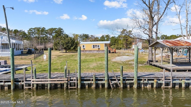 dock area with a lawn, fence, and a water view