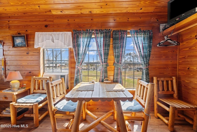 dining room featuring wood finished floors and wood walls