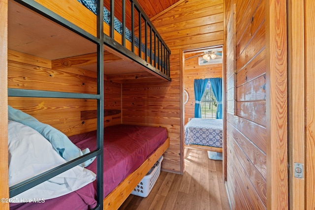 bedroom featuring wood finished floors, wood ceiling, wood walls, and vaulted ceiling