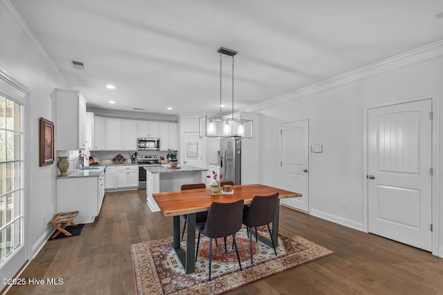 dining space with dark wood-style floors, visible vents, and ornamental molding