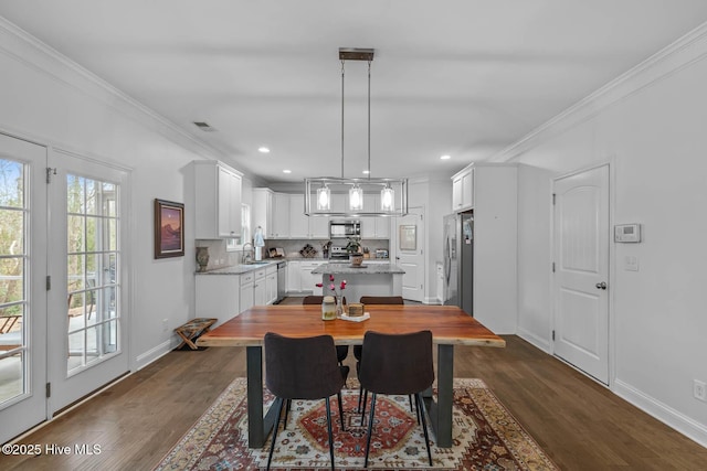 dining room featuring ornamental molding, dark wood-style flooring, and baseboards