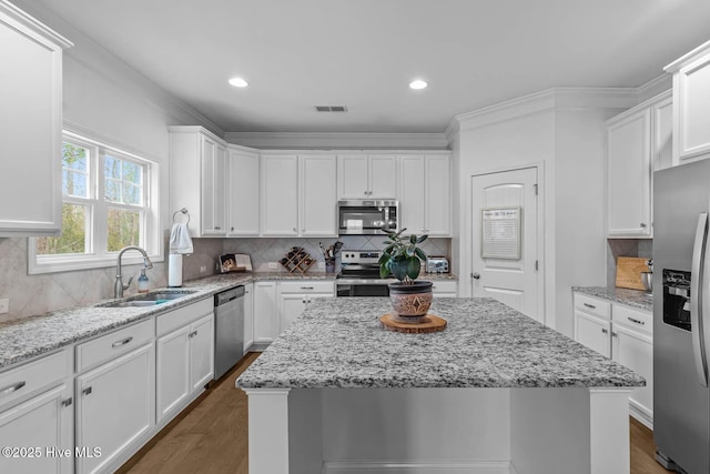 kitchen with visible vents, appliances with stainless steel finishes, white cabinets, and a sink