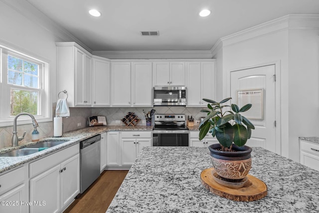 kitchen featuring appliances with stainless steel finishes, a sink, and white cabinetry