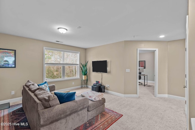 carpeted living area featuring visible vents and baseboards