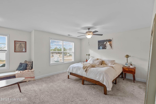 carpeted bedroom featuring visible vents, baseboards, and a ceiling fan