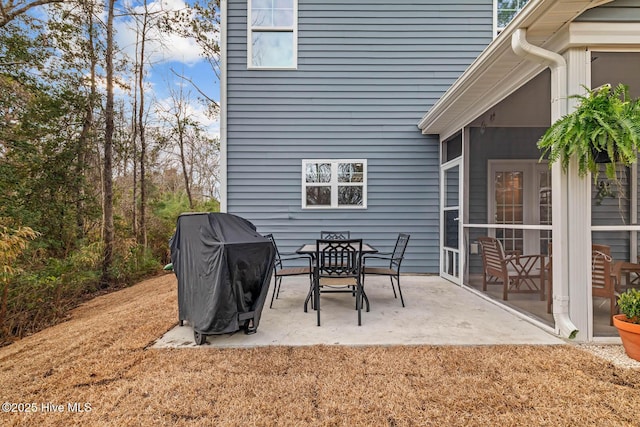 view of patio / terrace with a sunroom and a grill