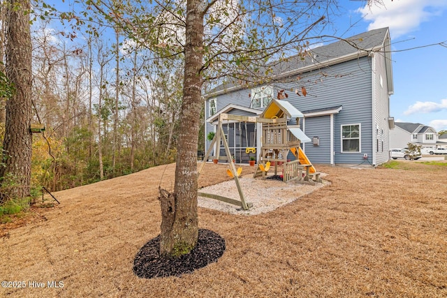 exterior space with a sunroom, a playground, and a front lawn