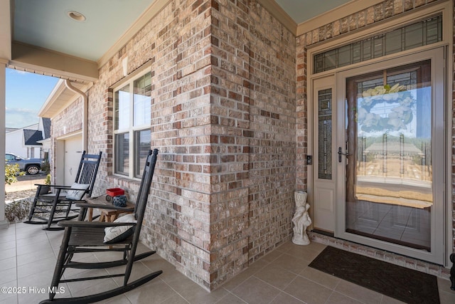 entrance to property featuring brick siding and covered porch