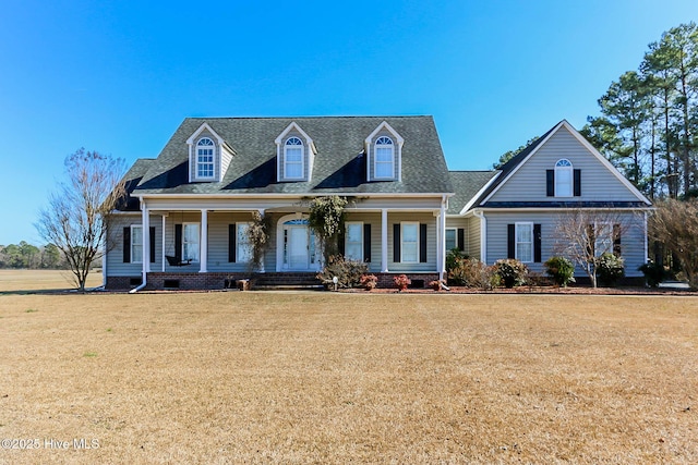 cape cod-style house with crawl space, a shingled roof, a porch, and a front yard