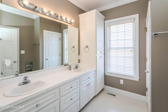 full bath with double vanity, baseboards, ornamental molding, and a sink