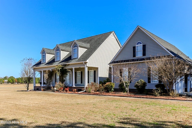 cape cod house featuring a front yard and covered porch