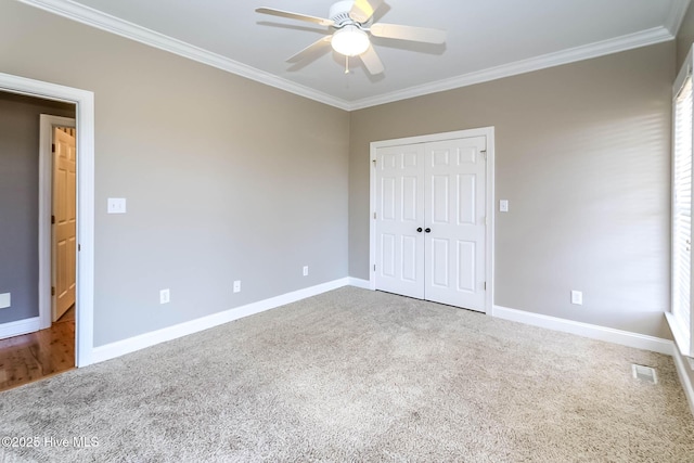 unfurnished bedroom featuring carpet, baseboards, and crown molding