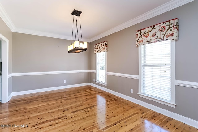 interior space with plenty of natural light, crown molding, baseboards, and wood finished floors