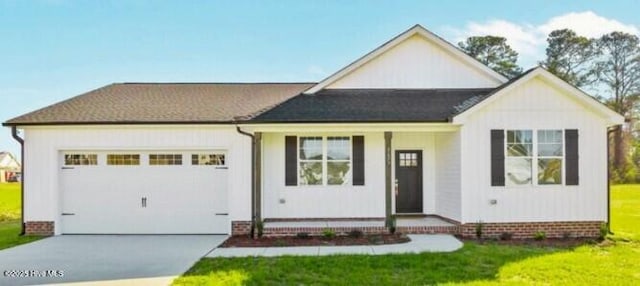 view of front of home with an attached garage, a front lawn, and concrete driveway