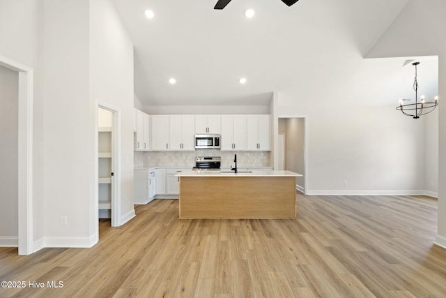 4506 Fairhaven Dr W, Wilson, NC 27893 - kitchen featuring stainless steel appliances, light countertops, a ceiling fan, white cabinets, and a kitchen island with sink