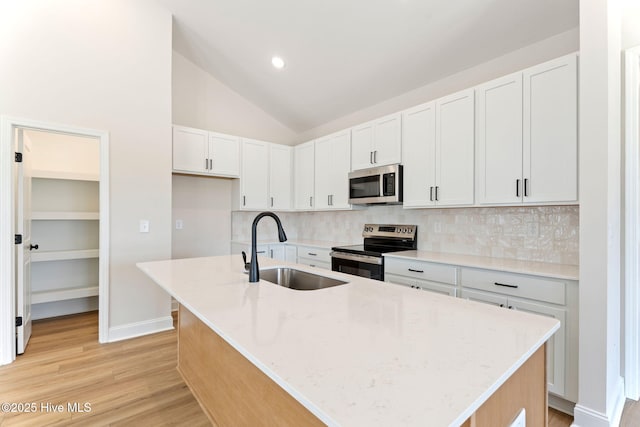 4506 Fairhaven Dr W, Wilson, NC 27893 - kitchen featuring stainless steel appliances, backsplash, a center island with sink, light stone countertops, and light wood-style floors
