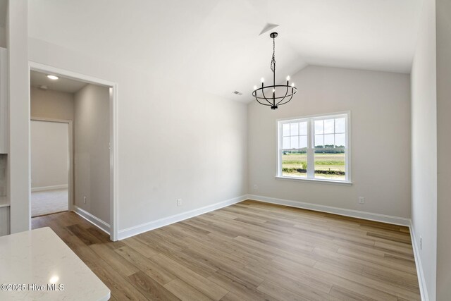 4506 Fairhaven Dr W, Wilson, NC 27893 - unfurnished dining area featuring a chandelier, light wood-style flooring, and vaulted ceiling