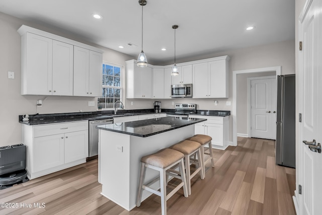 kitchen featuring stainless steel appliances, a breakfast bar, and white cabinets